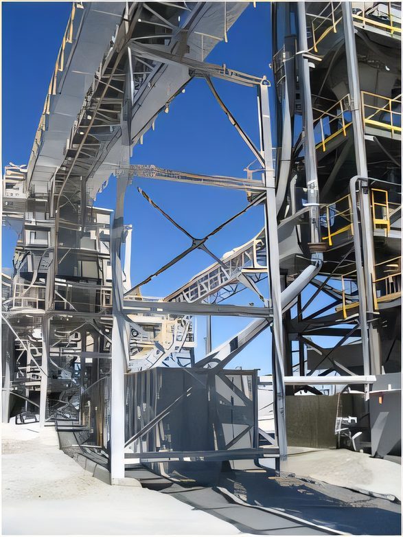 Galvanized conveyor structure climbing against a blue sky at a mine site