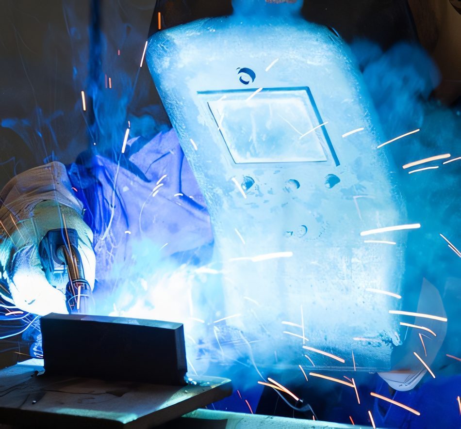Close on the welding mask, lit blue by the arc