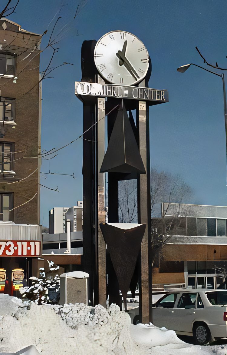 A steel clock tower for the Commerce Center standing in the snow, its frame in plain view